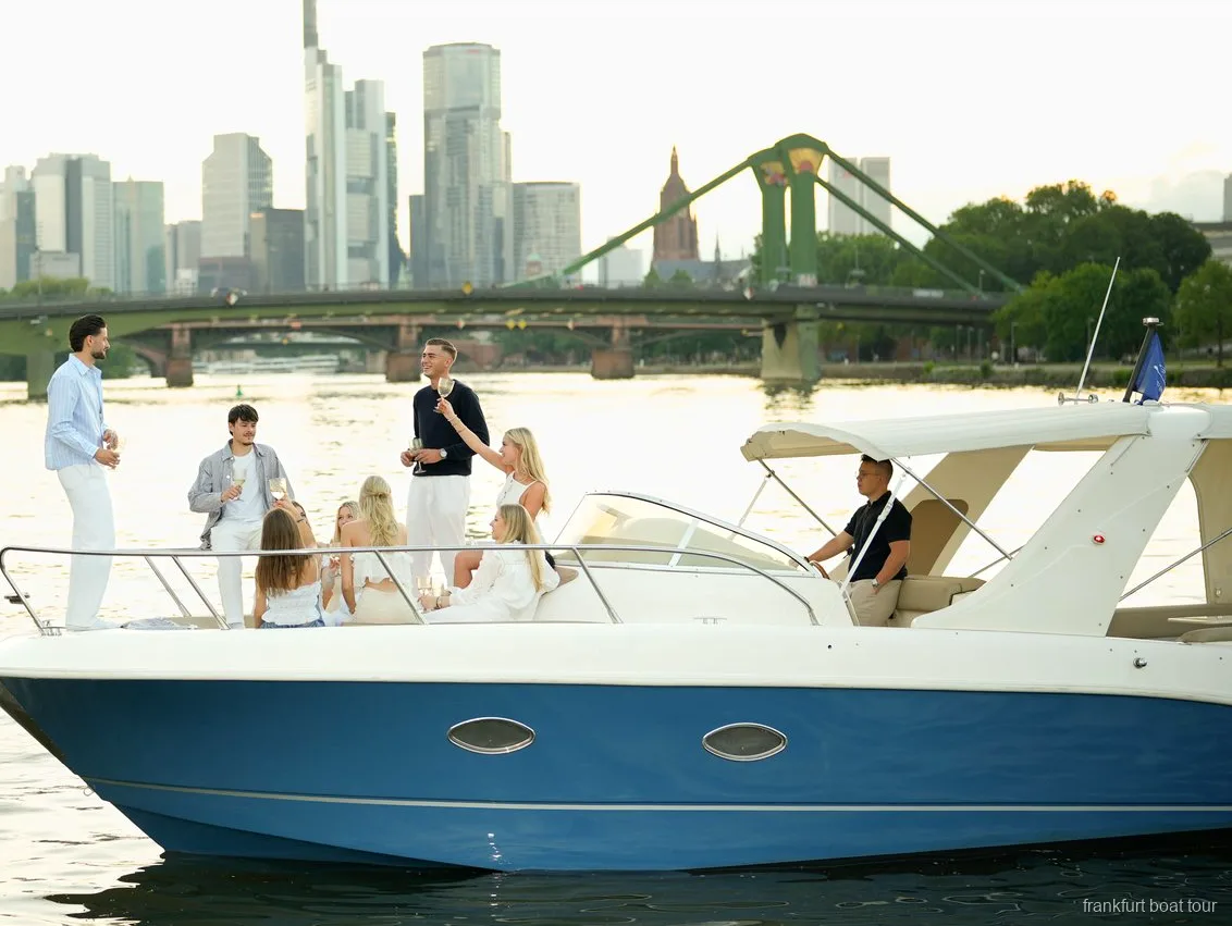 Private boat tour in Frankfurt sailing past the skyline with guests on the lounging deck