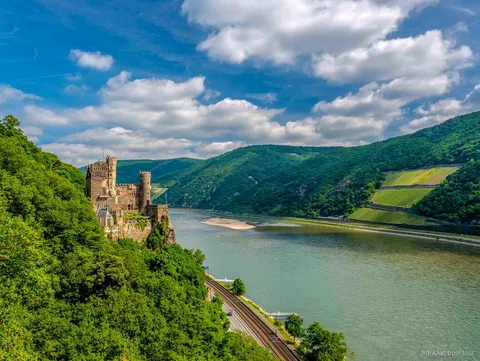 Rheinschifffahrt-Boot fährt an Weinbergterrassen nahe Rüdesheim vorbei